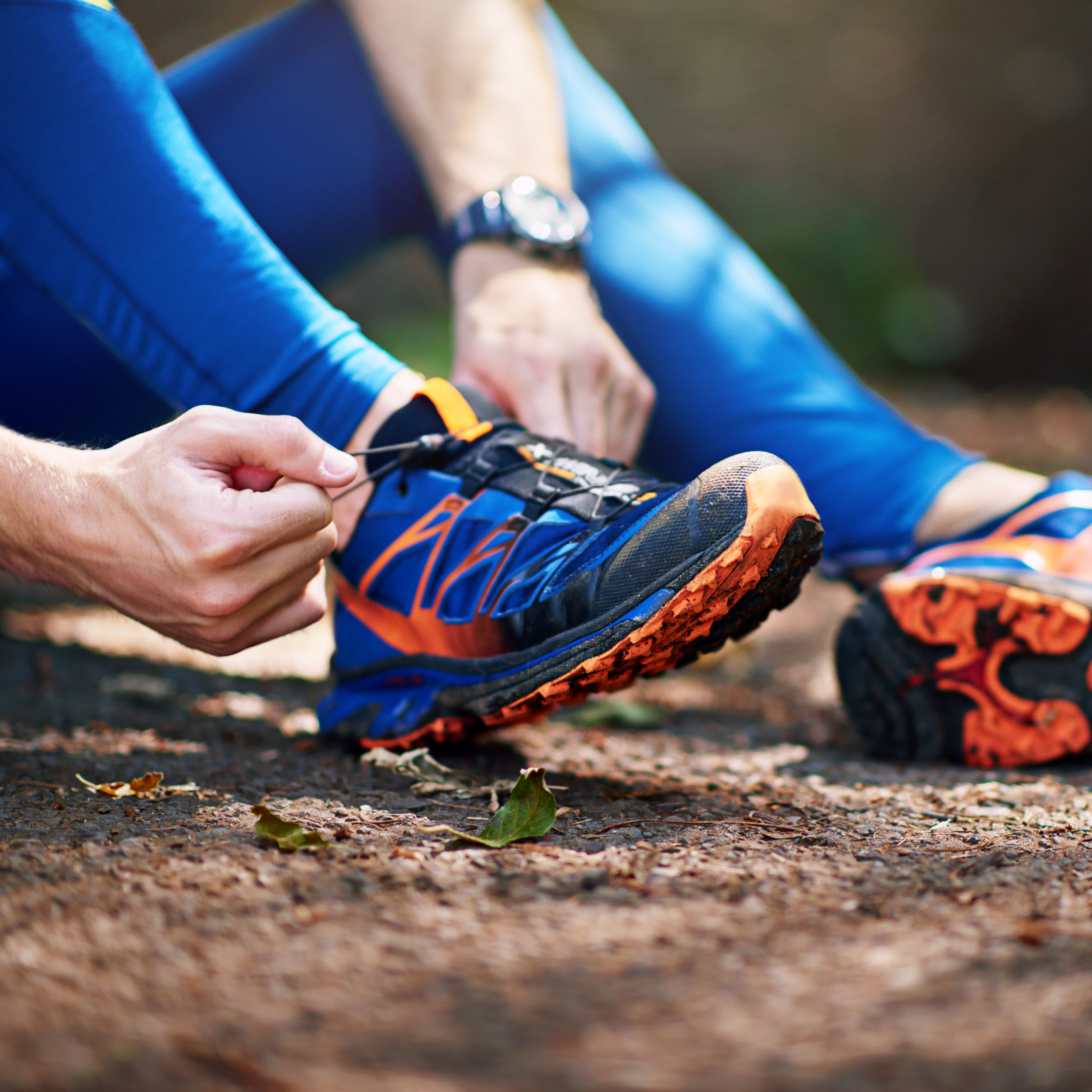 Man, forest and tying shoes for running with nature exercise, strong body and prepare for outdoor sport. Male athlete, woods and fasten sneakers on ground with getting ready, training and wellness.